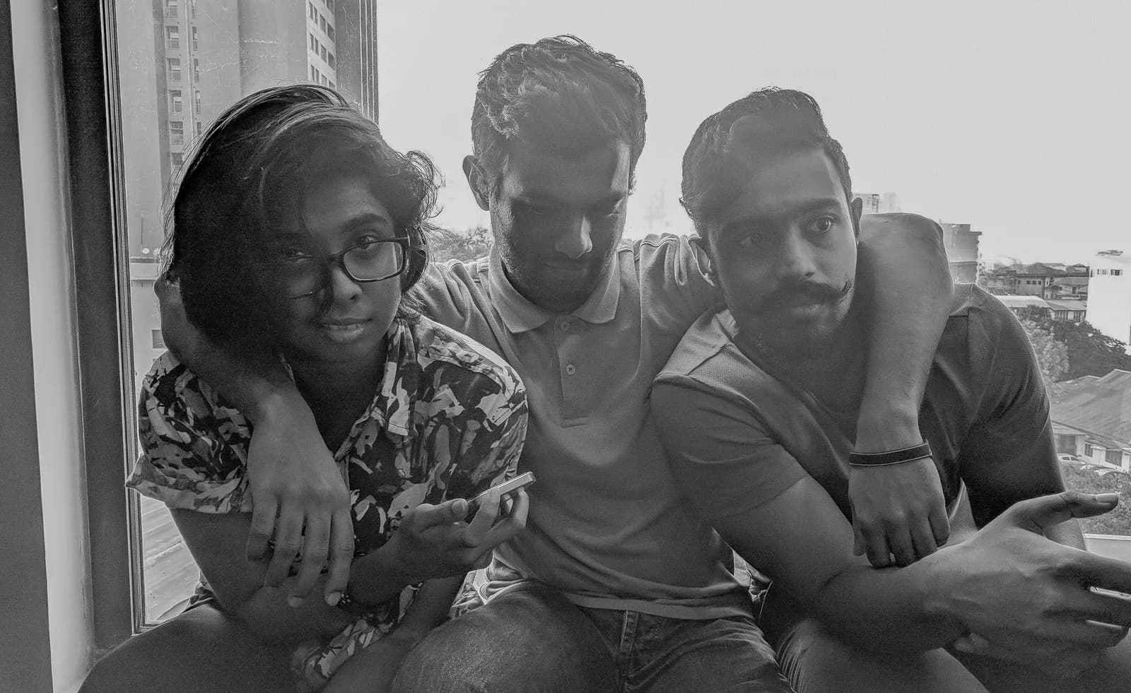 Three colleagues reviewing work together in black and white