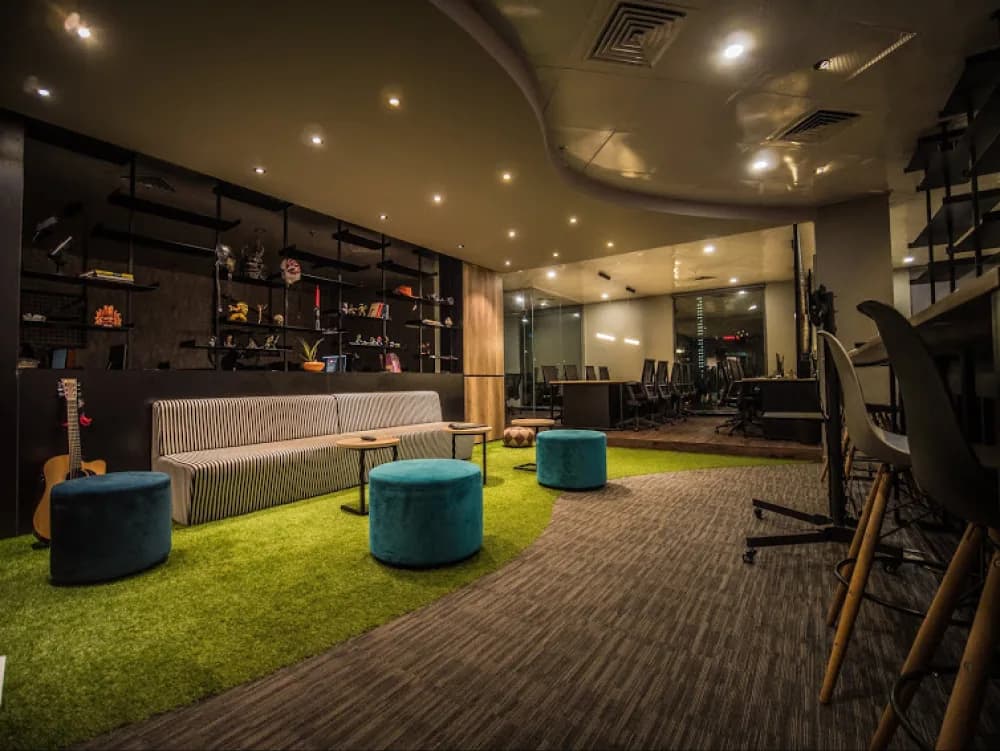 Studio lounge with bright stools and a green seating area
