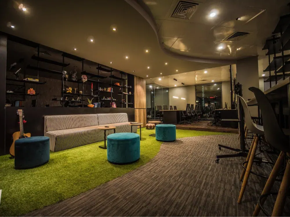 Studio lounge with bright stools and a green seating area